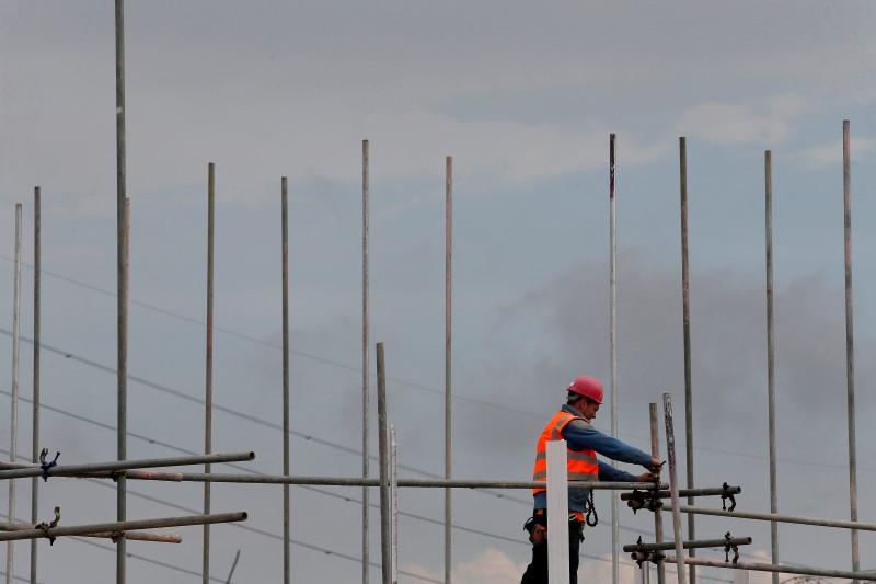 © Reuters. A scaffolder works at a construction site for the Ebbsfleet garden city in Ebbsfleet, southern England
