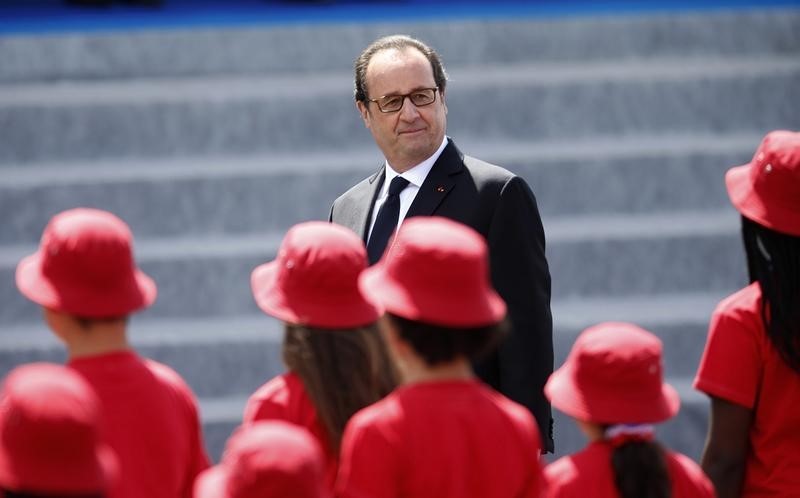 © Reuters. French President Francois Hollande attends the Bastille Day military parade on the Champs-Elysees in Paris