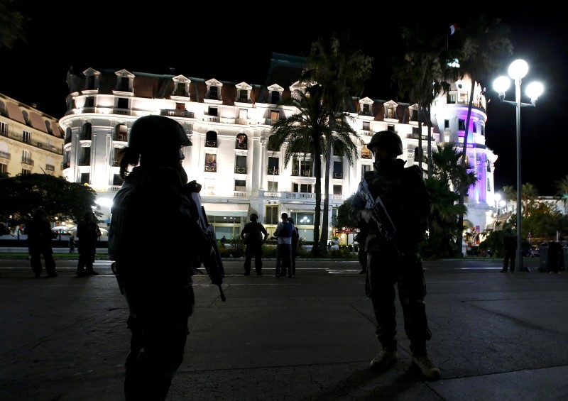 © Reuters. French soldiers secure the street after at least 30 people were killed in Nice, France, when a truck ran into a crowd celebrating the Bastille Day national holiday