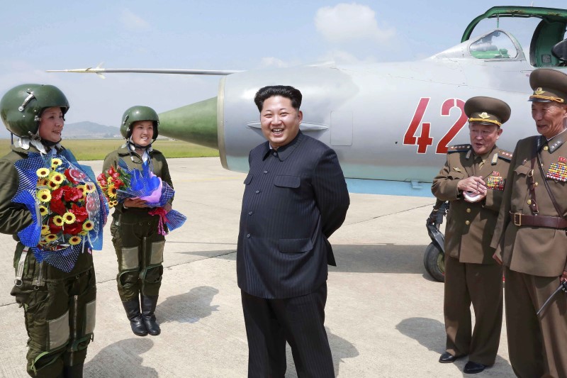 © Reuters. KCNA picture shows North Korean leader Kim Jong Un smiling as he attends a flight training session by female fighter pilots Jo Kum Hyang and Rim Sol