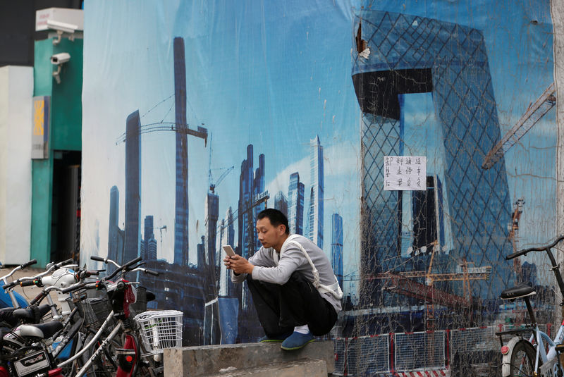© Reuters. A worker rests outside a construction site in Beijing's central business district