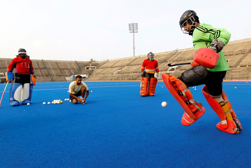 © Reuters. Hockey goalkeepers train with their coach at the Gaddafi hockey stadium in Lahore