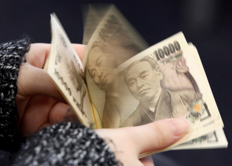 © Reuters. Женщина пересчитывает банкноты достоинством 10.000 иен