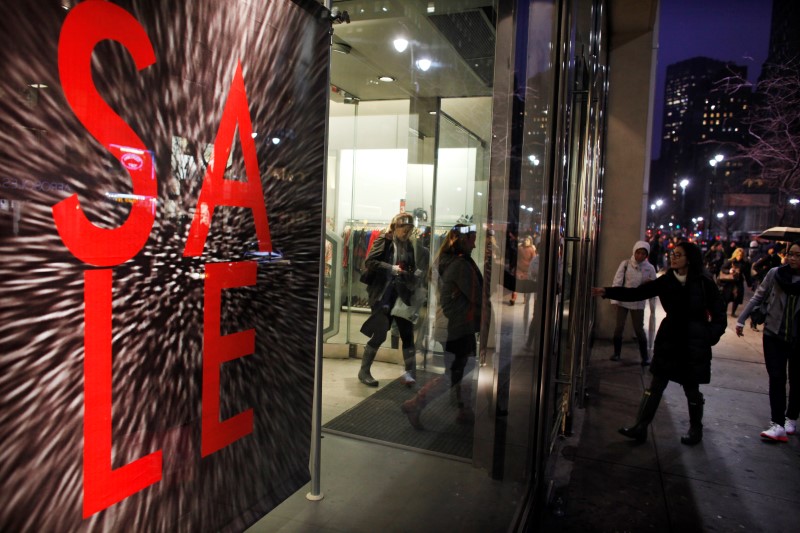 © Reuters. Shoppers leave and enter a store in New York