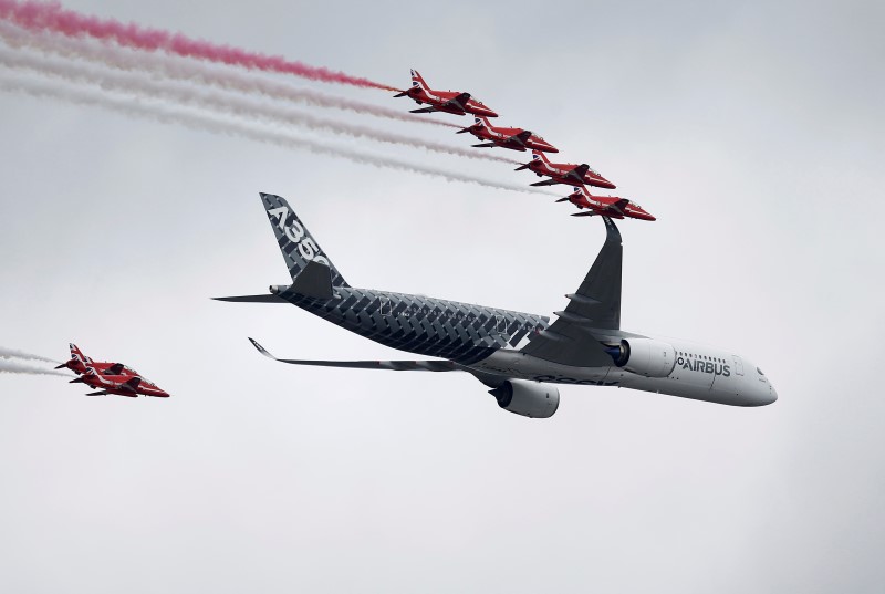 © Reuters. An Airbus A350 aircraft flies in formation with Britain's Red Arrows flying display team at the Farnborough International Airshow in Farnborough