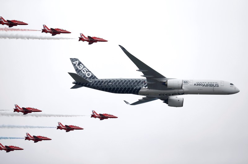 © Reuters. An Airbus A350 aircraft flies in formation with Britain's Red Arrows flying display team at the Farnborough International Airshow in Farnborough
