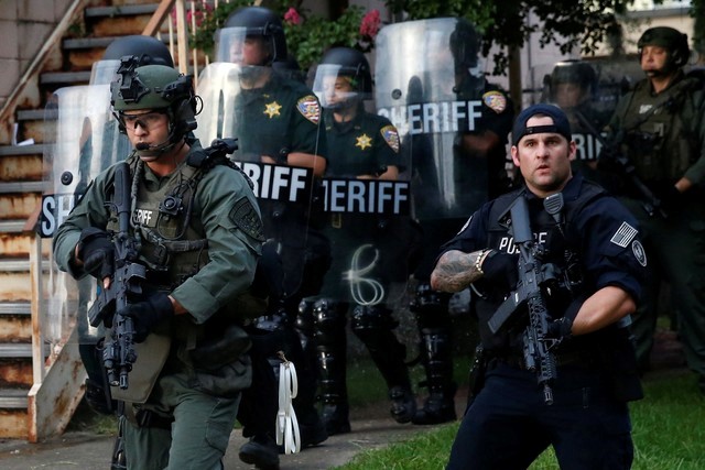 © Reuters. File photo of law officers marching down a street during protests in Baton Rouge