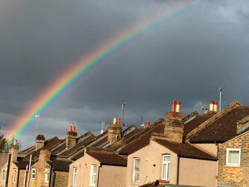 © Reuters. A rainbow forms over terraced housing during a rain storm in south London