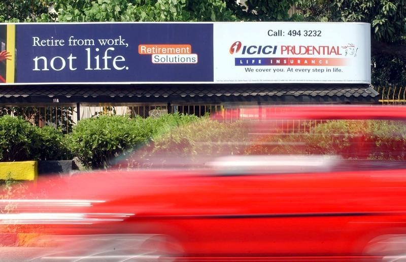 © Reuters. VEHICLE PASSES A LIFE INSURANCE BILL BOARD IN BOMBAY.