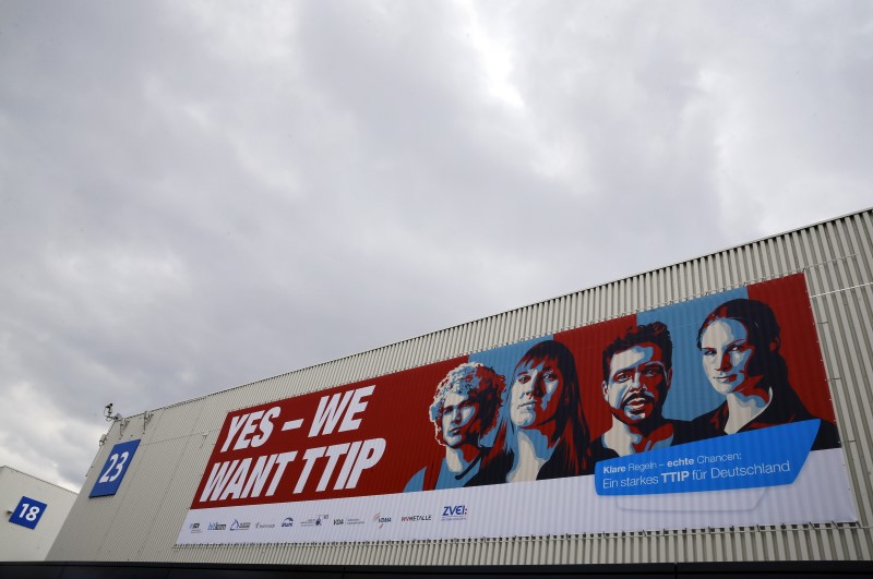 © Reuters. Dark clouds are seen over a hall of the Hanover Fair decorated with a banner supporting the free trade agreement TTIP in Hanover