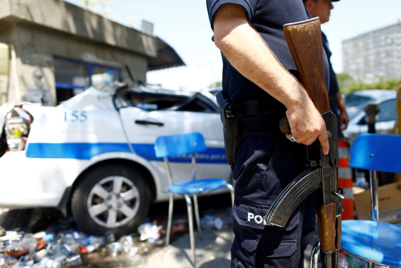 © Reuters. Policial ao lado de carro destruído em Ancara