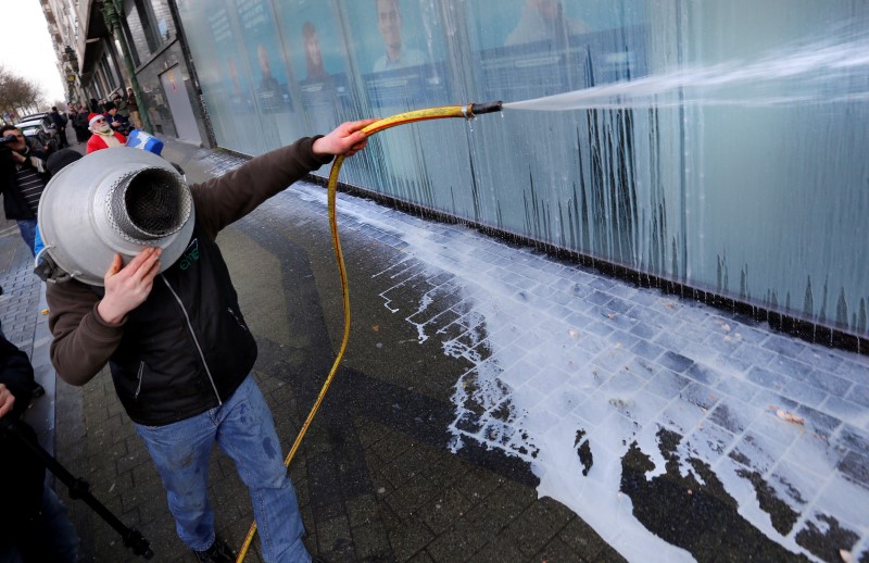 © Reuters. A dairy farmer sprays milk outside the MR political party during a demonstration in Brussels