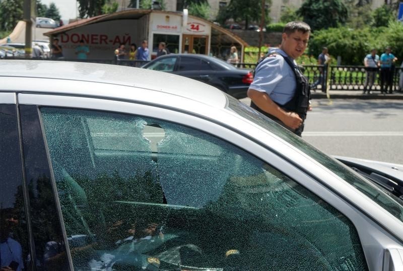 © Reuters. A bullet hole is seen on the window of a car parked in the street in Almaty