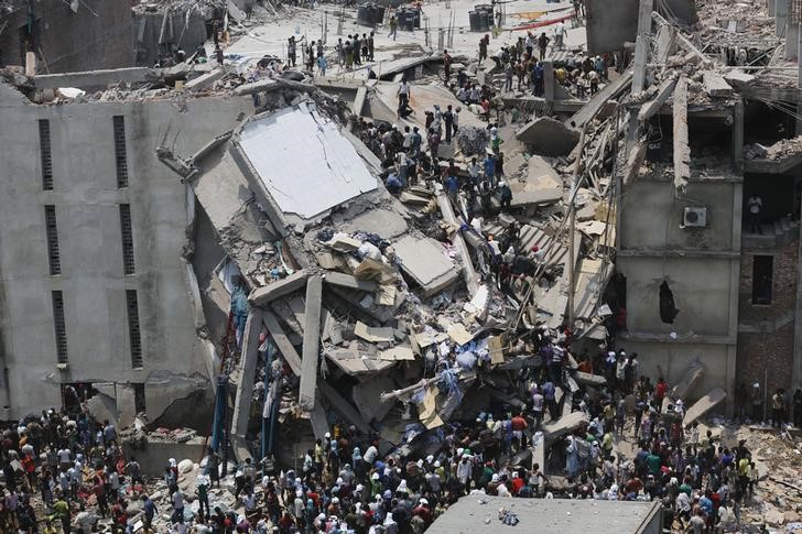 © Reuters. People rescue garment workers trapped under rubble at the Rana Plaza building after it collapsed, in Savar