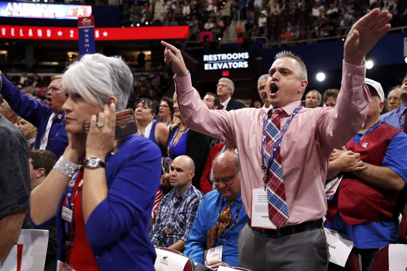 © Reuters. A delegate puts her fingers in her ears as other delegates scream and yell at the Republican National Convention in Cleveland
