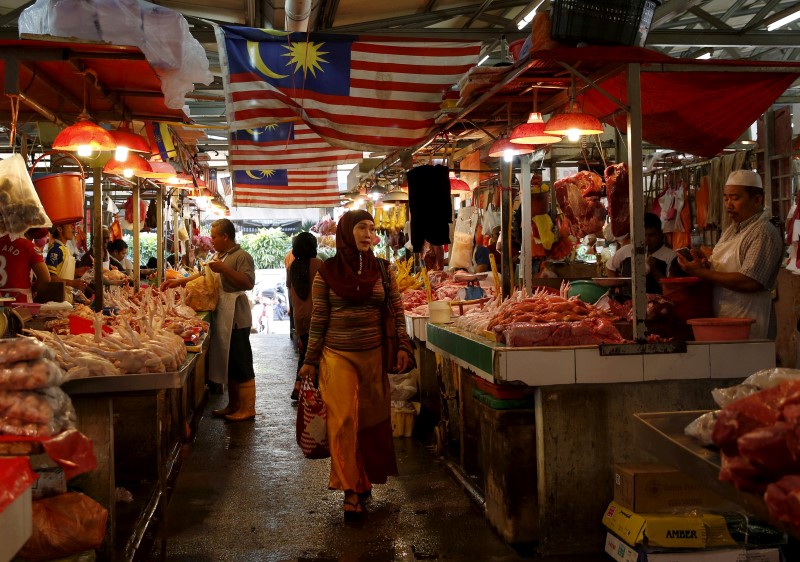 © Reuters. A woman shops in a wet market in Kuala Lumpur