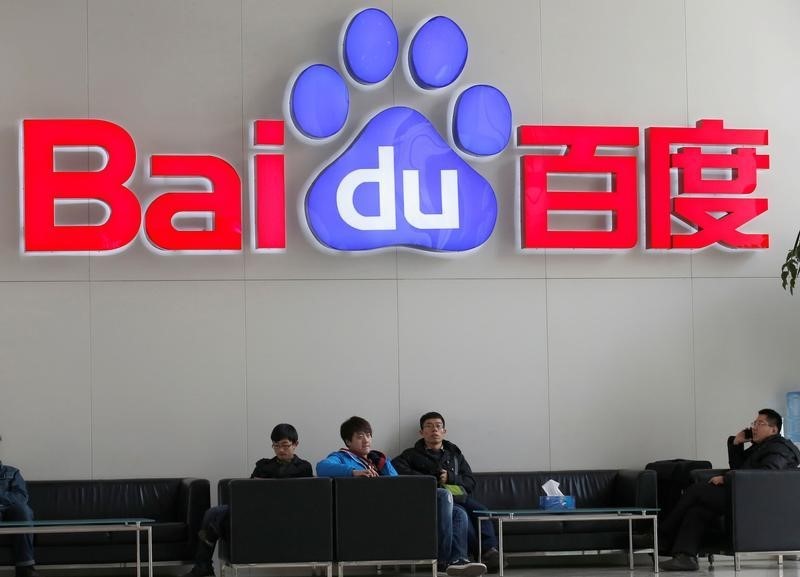 © Reuters. People sit in front of the company logo of Baidu at its headquarters in Beijing