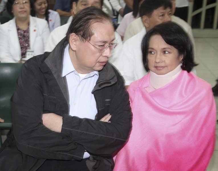 © Reuters. File photo of Former Philippine President Arroyo talking to husband, Miguel, inside courtroom of the Sandiganbayan anti-graft court in Quezon City