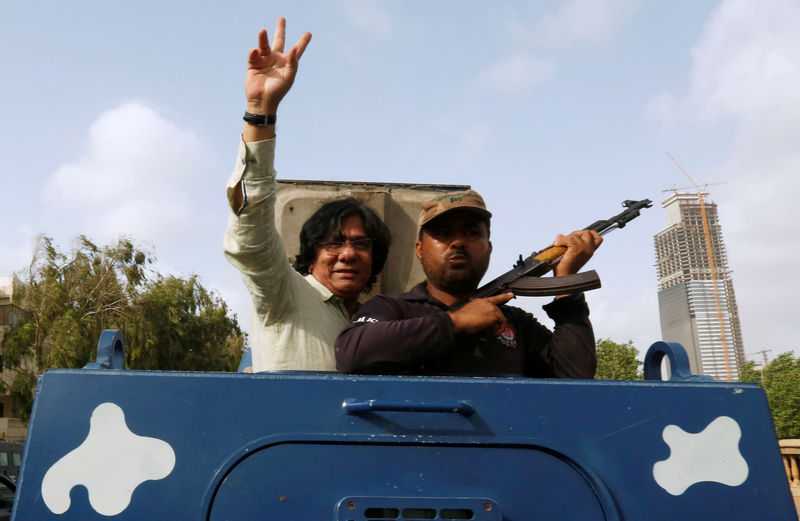 © Reuters. Rauf Siddiqui, leader of political party Muttahida Qaumi Movement MQM, gestures from an armored personal carrier while being taken to jail after his arrest from Anti Terrorism Court ATC, in Karachi