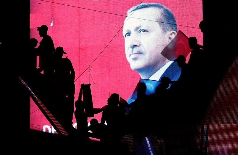 © Reuters. Turkish Supporters are silhouetted against a screen showing President Tayyip Erdogan during a pro-government demonstration in Ankara