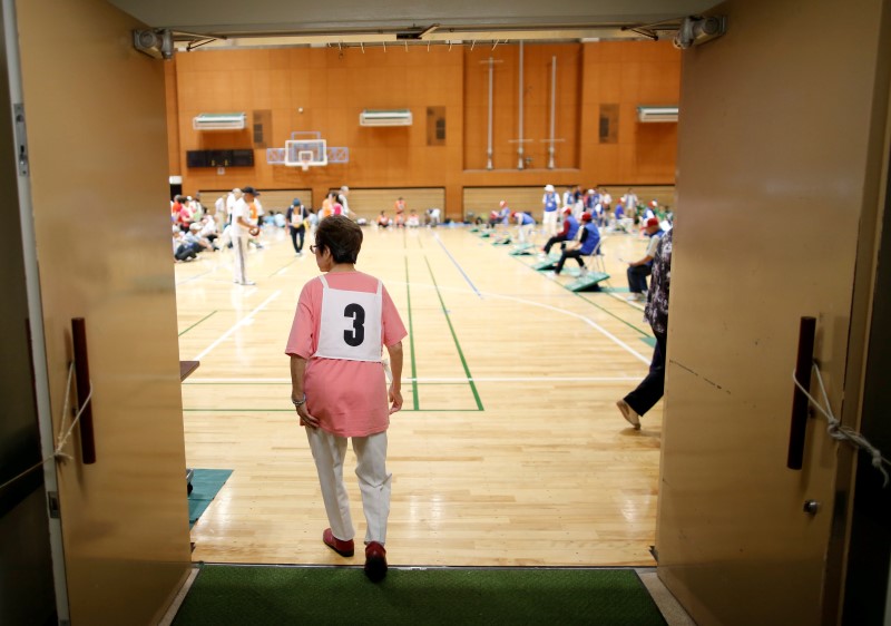 © Reuters. An elderly participant walks into a venue for a ring throwing sports event at a gymnasium in Tokyo, Japan