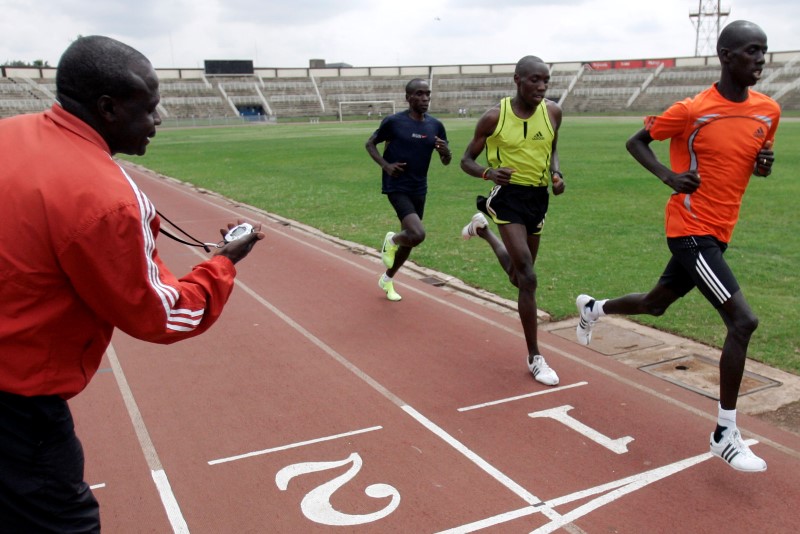 © Reuters. Kenya's National Athletics head coach Kirwa looks at his watch as athletes run during a training session at Nyayo National Stadium in Nairobi