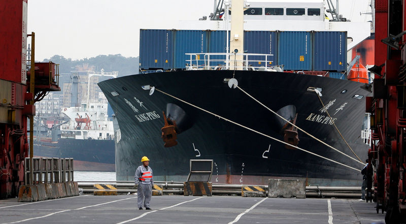 © Reuters. A man stands in front of a cargo ship at a port in the northern Taiwan city of Keelung