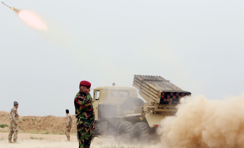 © Reuters. Iraqi soldiers fire a rocket toward Islamic State militants on the outskirt of the Makhmour south of Mosul