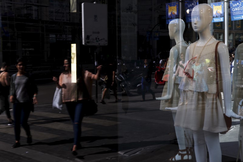 © Reuters. A woman points at a store in a commercial district in Madrid