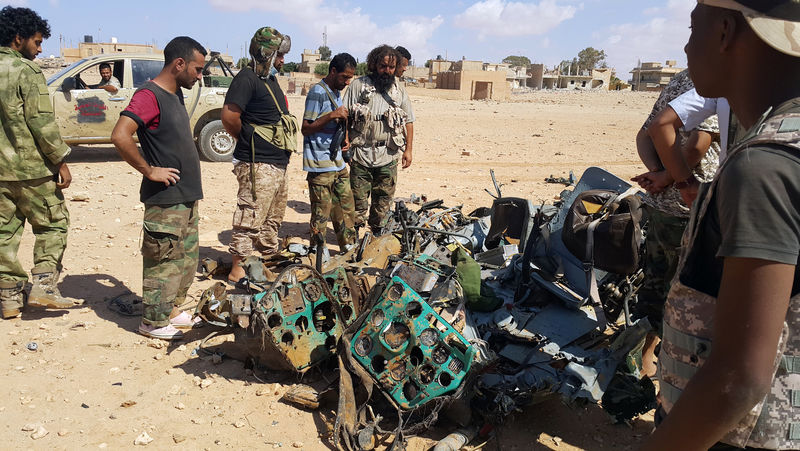 © Reuters. Libyans gather around the remains of a helicopter that crashed near Benghazi