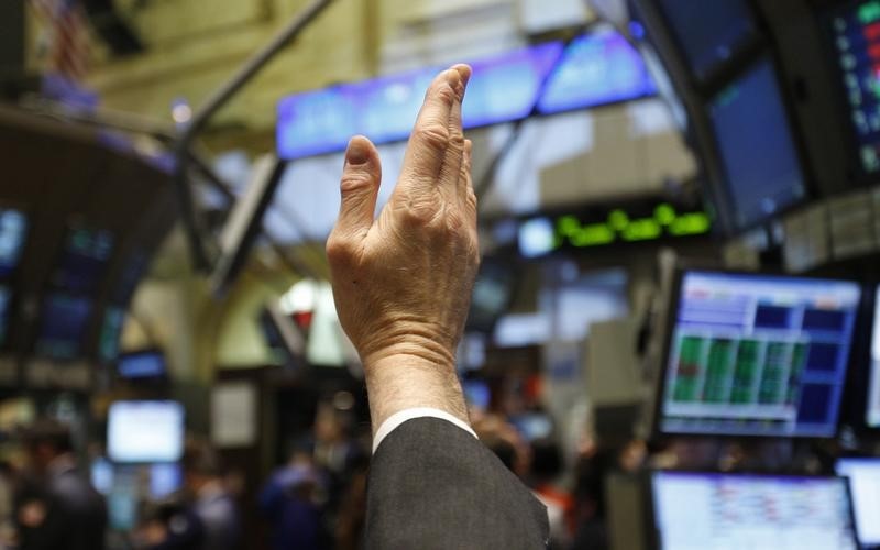 © Reuters. A trader raises his hand to bid on stock prices as he works on the main trading floor of the New York Stock Exchange early in the trading session