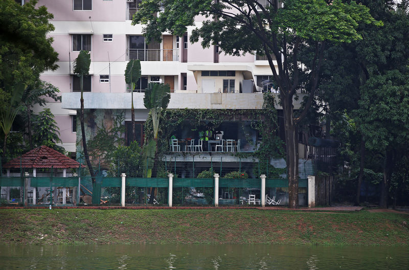 © Reuters. Policemen inspect a site after gunmen attacked the Holey Artisan Bakery and the O'Kitchen Restaurant, in Dhaka, Bangladesh