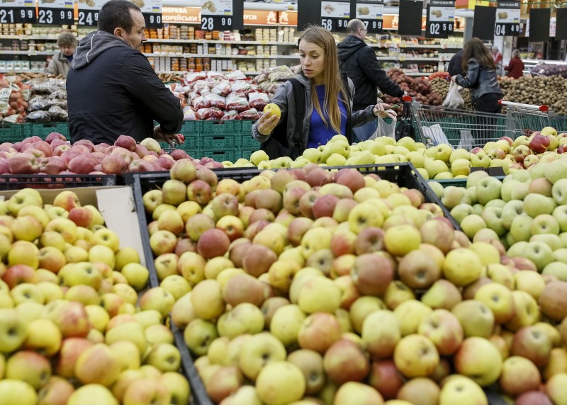 © Reuters. A customer selects apples at a supermarket in Kiev