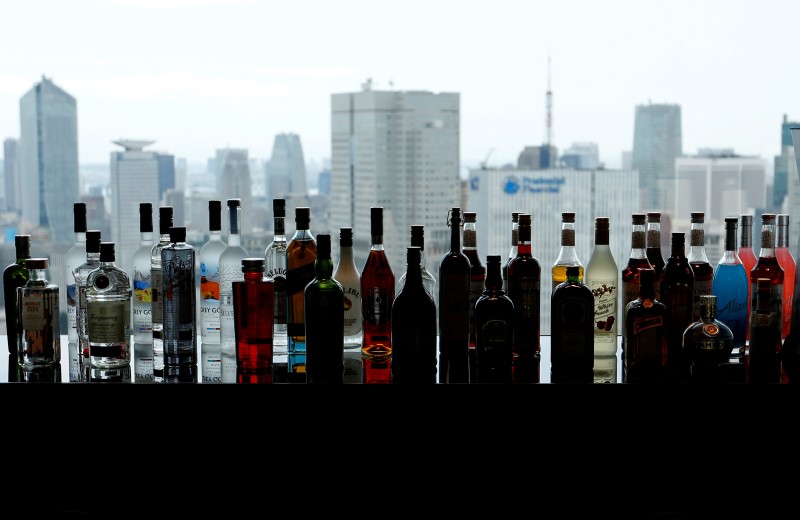 © Reuters. Bottles of liquors are seen in front of high rise office buildings at a hotel bar in Tokyo