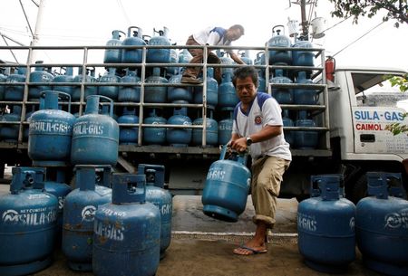 © Reuters. Workers deliver LPG tanks to a retailer in Manila