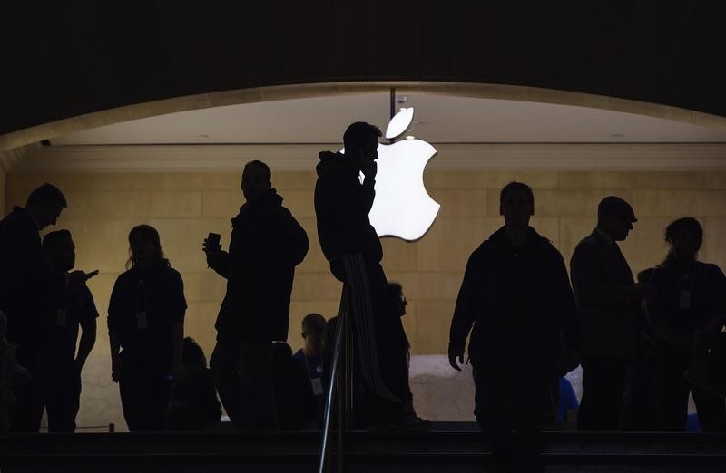 © Reuters. A man talks on his telephone as customers walk through an Apple store in Grand Central Terminal in New York