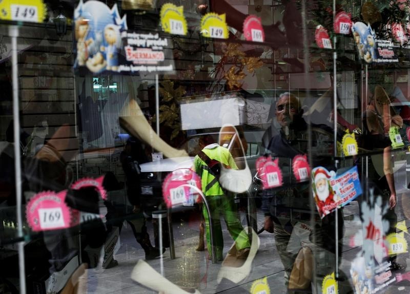 © Reuters. A man is reflected on a window at a shoe shop in downtown Mexico City