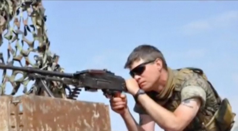 © Reuters. Levi Jonathan Shirley, an American volunteer with Kurdish forces, uses a light machine gun in an unknown location in this still image taken from video