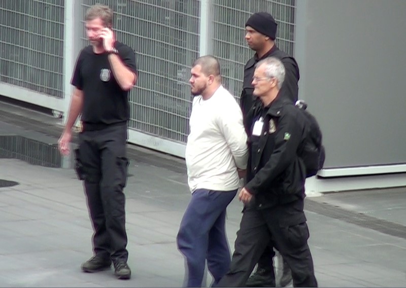 © Reuters. Brazilian Federal Police officers escort one of the 10 people they arrested on suspicions of ties to Islamic State in Sao Paulo