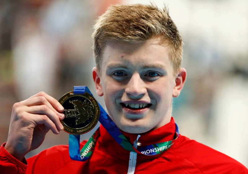 © Reuters. Peaty of Britain poses with his gold medal after the men's 50m breaststroke final at the Aquatics World Championships in Kazan
