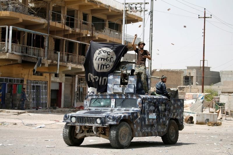 © Reuters. Members of Iraqi government forces celebrate on a street in Falluja