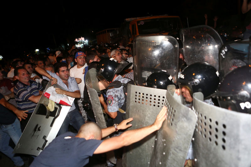 © Reuters. Riot police clash with demonstrators who had gathered in show of support for gunmen holding several hostages in police station in Yerevan