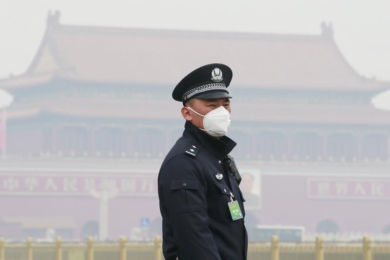 © Reuters. Un policía que usa una máscara para protegerse de la grave contaminación asegura el área cerca del Gran Salón del Pueblo antes de la sesión de apertura de la Conferencia Consultiva Política del Pueblo Chino en Pekín