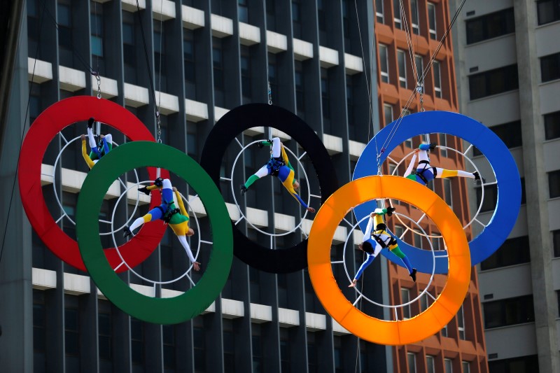 © Reuters. Acrobats perform on the Olympics rings at Paulista Avenue in Sao Paulo's financial center