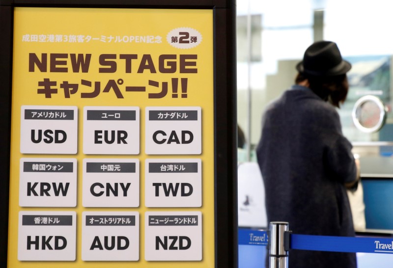 © Reuters. Currency signs are seen at an exchange office as a woman exchanges money at Narita International airport