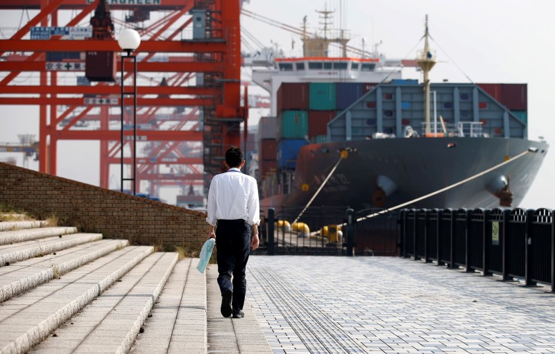 © Reuters. A man walks near a container ship at a port in Tokyo