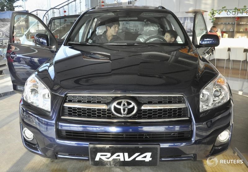 © Reuters. Клиенты проверяют Toyota Rav 4 в магазине Toyota в Тяньцзине