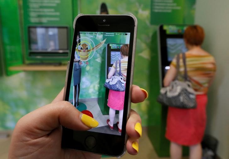 © Reuters. Woman plays augmented reality mobile game "Pokemon Go" by Nintendo at branch of Sberbank in central Krasnoyarsk