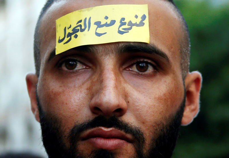 © Reuters. A man with a sticker on his forehead attends a demonstration against sectarianism, also calling for abolishing curfews put on Syrian refugees in Beirut