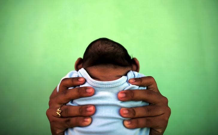 © Reuters. Mulher segurando bebê com microcefalia em Olinda